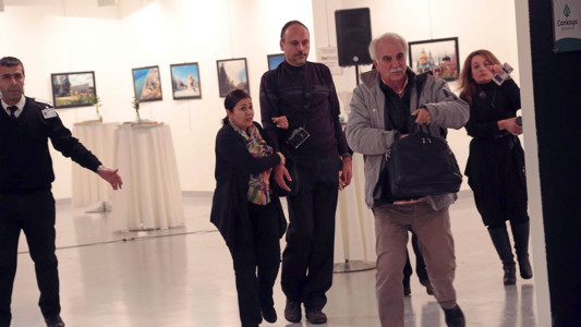 Spectators are evacuated after a gunman shot the Russian Ambassador to Turkey, Andrei Karlov, at a photo gallery in Ankara, Turkey, Monday, Dec. 19, 2016. (AP Photo/Burhan Ozbilici)