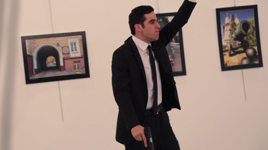 Mevlut Mert Altintas, a 22 year old Turkish policeman, gestures after shooting the Russian Ambassador to Turkey, Andrei Karlov, at a photo gallery in Ankara, Turkey, Monday, Dec. 19, 2016. (AP Photo/Burhan Ozbilici)