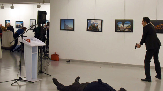 Andrey Karlov, the Russian ambassador to Ankara, lies on the floor next to his killer who still point his gun to people attending an art exhibition in Ankara, on December 19, 2016.
AFP PHOTO / STRINGER