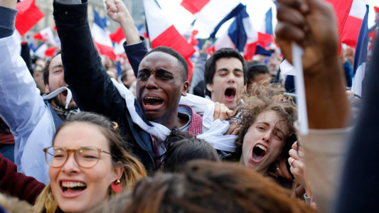Supporters of French independent centrist presidential candidate, Emmanuel Macron react outside the Louvre museum in Paris, France, Sunday, May 7, 2017. Polling agencies have projected that centrist Emmanuel Macron will be France's next president, putting a 39-year-old political novice at the helm of one of the world's biggest economies and slowing a global populist wave. The agencies projected that Macron defeated far-right leader Marine Le Pen 65 percent to 35 percent on Sunday. (AP Photo/Laurent Cipriani)