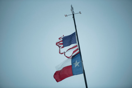A Texas and US flag are seen as rain from Hurricane Henry falls on August 26, 2017 in Texas City, Texas.
Hurricane Harvey slammed into the Texas coast late Friday, unleashing torrents of rain and packing powerful winds, the first major storm to hit the US mainland in 12 years. / AFP PHOTO / Brendan Smialowski Hurricane Harvey Slams Into Texas Gulf Coast