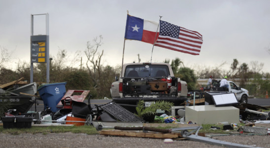 The Texas state flag and American flag wave in the wind over an area of debris left behind in the wake of Hurricane Harvey, Sunday, Aug. 27, 2017, in Rockport, Texas. (AP Photo/Eric Gay)
