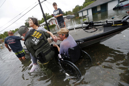 Members of the Louisiana Department of Wildlife and Fisheries help rescue Mike Henry, right, and his partner Rosemarie Carpenter during flooding from Tropical Storm Harvey in Orange, Texas, Wednesday, Aug. 30, 2017. (AP Photo/Gerald Herbert)