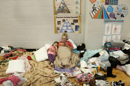 CHANNELVIEW, TX - AUGUST 29: Christine Garcia relaxes with her eight-year-old daughter Mia in the Channelview High School gym which has been turned in to an evacuation shelter for victims of flooding following Hurricane Harvey on August 29, 2017 in Channelview, Texas. (Scott Olson/Getty Images/AFP)