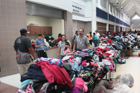 CHANNELVIEW, TX - AUGUST 29: People look over donated clothing items at a shelter after they were displaced when their neighborhoods were flooded with rain water following Hurricane Harvey on August 29, 2017 in Channelview, Texas. (Scott Olson/Getty Images/AFP)