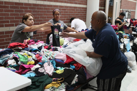 CHANNELVIEW, TX - AUGUST 29: Volunteers sort through donated clothing items at a shelter which will be distibuted to families displaced after their neighborhoods were inundated with rain water following Hurricane Harvey on August 29, 2017 in Channelview, Texas. (Scott Olson/Getty Images/AFP)
