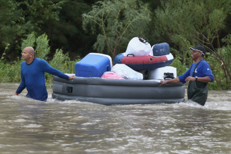 HOUSTON, TX - AUGUST 29: People make their way out of a flooded neighborhood after it was inundated with rain water following Hurricane Harvey on August 29, 2017 in Houston, Texas. (Scott Olson/Getty Images/AFP)