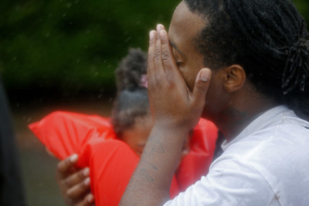 Demetres Fair wipes his eyes as he holds his daughter Damouri Fair, 2, as he is rescued by boat by members of the Louisiana Department of Wildlife and Fisheries and the Houston Fire Department during flooding from Tropical Storm Harvey in Houston, Monday, Aug. 28, 2017. (AP Photo/Gerald Herbert)