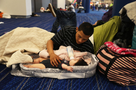 HOUSTON, TX - AUGUST 29: Mark Ocosta and his baby Aubrey Ocosta take shelter at the George R. Brown Convention Center after flood waters from Hurricane Harvey inundated the city on August 29, 2017 in Houston, Texas. The evacuation center which is overcapacity has already received more than 9,000 evacuees with more arriving. (Joe Raedle/Getty Images/AFP)