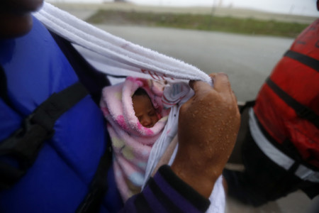 Demetria Fair holds a towel over her four-day-old daughter Dakota Fair, as they are rescued by boat by members of the Louisiana Department of Wildlife and Fisheries and the Houston Fire Department during flooding from Tropical Storm Harvey in Houston, Monday, Aug. 28, 2017. (AP Photo/Gerald Herbert)