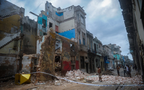 Cubans stand bt a collapsed building in Havana, on September 9, 2017. (AFP PHOTO / YAMIL LAGE)