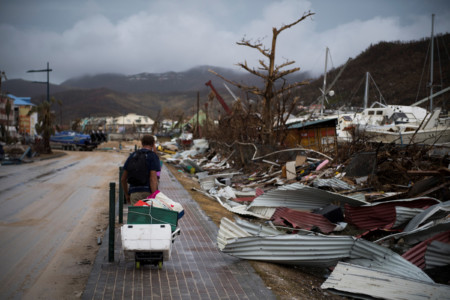 A sailor leaves with his belongings after loosing his boat in Marigot, on September 9, 2017 in Saint-Martin island devastated by Irma hurricane.
Officials on the island of Guadeloupe, where French aid efforts are being coordinated, suspended boat crossings to the hardest-hit territories of St. Martin and St. Barts where 11 people have died. (AFP PHOTO / Martin BUREAU)