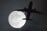 A plane flys in front of a "super moon" or "wolf moon" on its approach to London Heathrow Airport on January 1, 2018. (AFP PHOTO / Justin TALLIS)