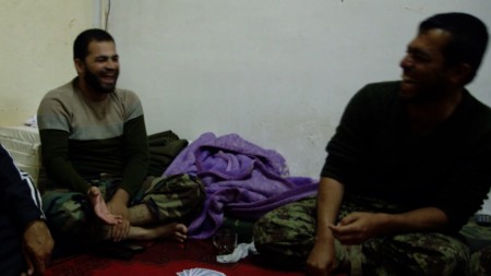 During a nighttime card game, a moment of levity helps soldiers escape the strain of their days.