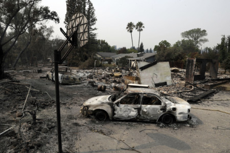Burned vehicles sit in front of a wildfire-ravaged home, Sunday, July 29, 2018, in Redding, Calif. (AP Photo/Marcio Jose Sanchez) Burned vehicles
