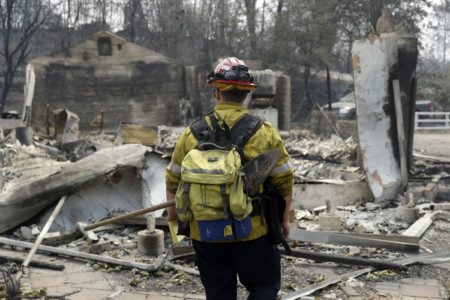 Capt. Scott Fisher, with the San Bernardino County Fire Department, surveys a wildfire-damaged neighborhood, Sunday, July 29, 2018, in Keswick, Calif. (AP Photo/Marcio Jose Sanchez) Capt. Scott Fisher