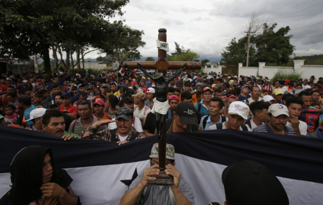 A Honduran migrant holds up a replica of the Black Christ of Esquipulas as Guatemalan police temporarily block the road after the caravan crossed the Honduras-Guatemala border without incident, in Esquipulas, Guatemala, Monday, Oct. 15, 2018. (AP Photo/Moises Castillo) A Honduran migrant holds up a replica of the Black Christ of Esquipulas