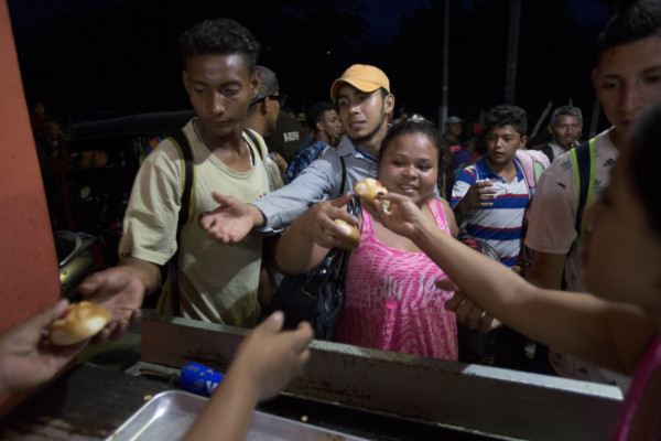 Honduran migrants receive free bread from residents of Esquipulas, Guatemala, Monday, Oct. 15, 2018, as they make their way to the U.S. (AP Photo/Moises Castillo) Honduran migrants receive free bread from residents of Esquipulas, Guatemala