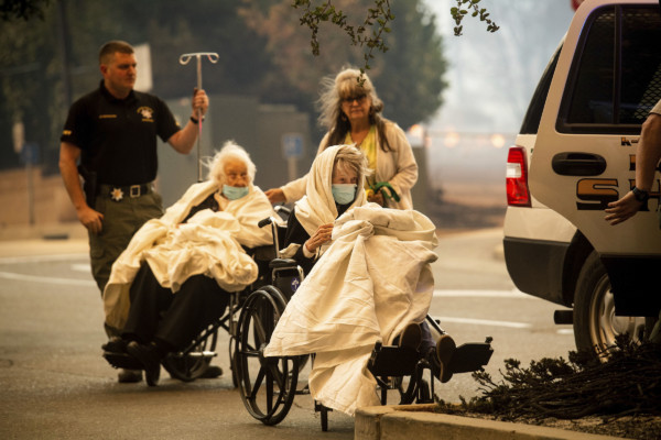 Emergency personnel evacuate patients as the Feather River Hospital burns