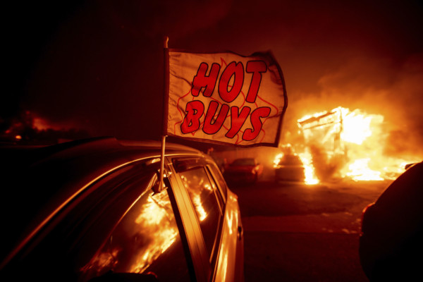 Flames consume a car dealership