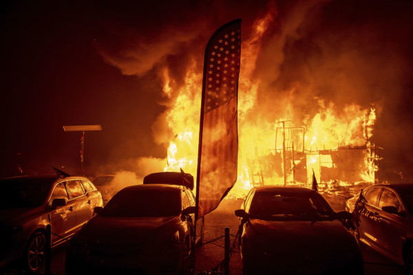 Flames consume a car dealership