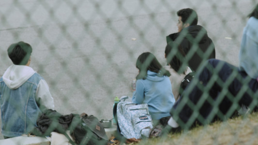 A group of students seen through the fence of a school.