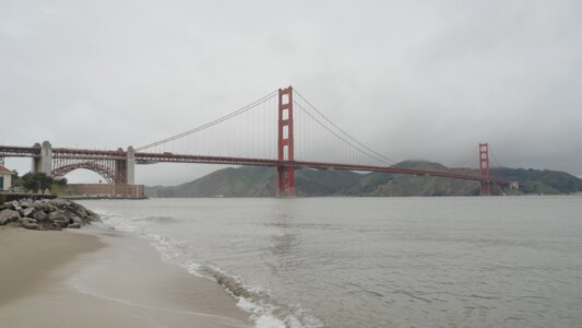 San Francisco's Golden Gate on a misty day, seen from the beach.