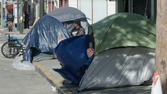 A couple of tents on the sidewalk in downtown San Francisco.